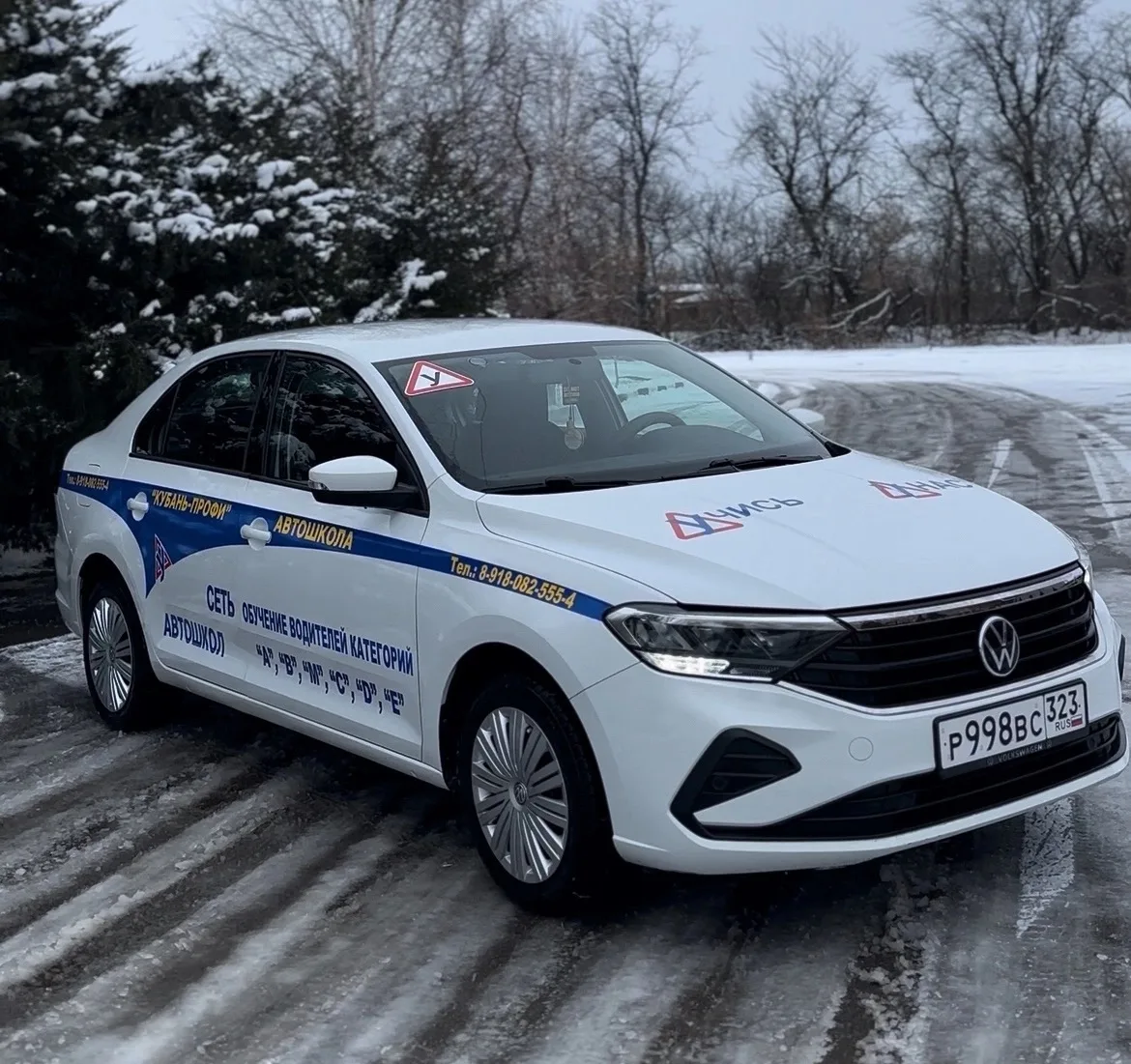 Белый Volkswagen с фирменной оклейкой автошколы